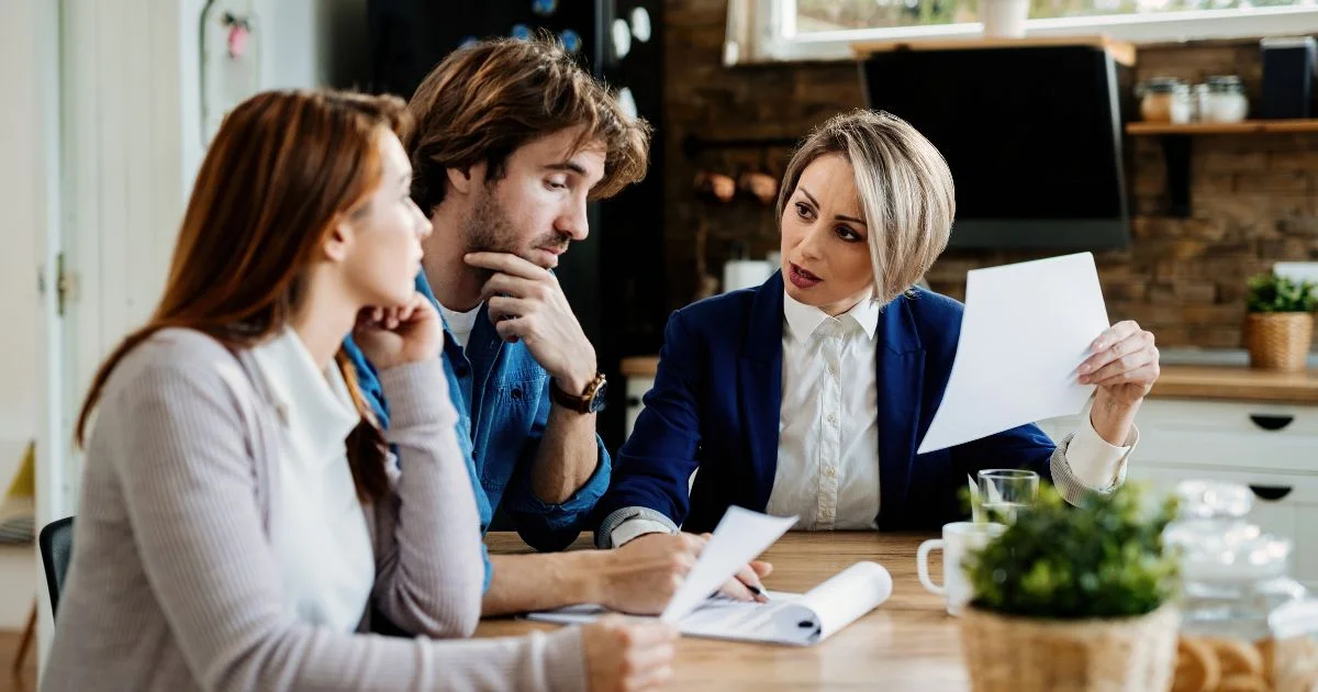 Lawyer reviewing documents with couple at table