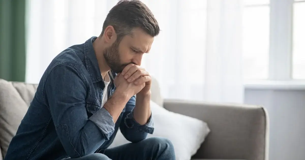 Worried man sitting alone in deep thought